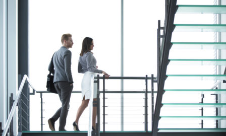 Young businesspeople walking on staircase in hallway